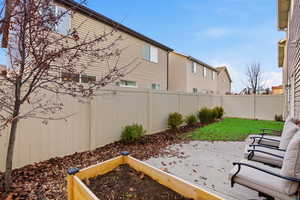 Fenced backyard featuring a patio and a garden