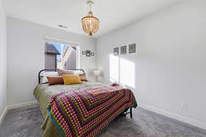 Bedroom featuring carpet and a chandelier