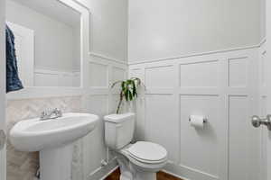 Bathroom with a decorative wall and wainscoting