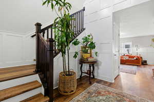 Staircase featuring a decorative wall and wood finished floors