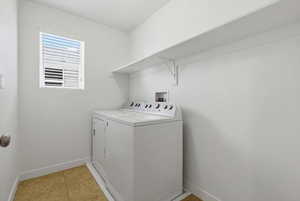 Laundry room featuring separate washer and dryer and light tile patterned floors