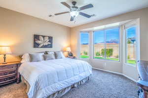 Bedroom featuring a mountain view, carpet, and ceiling fan