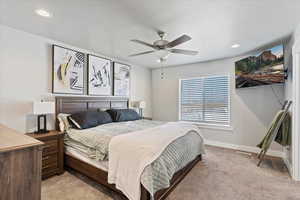 Bedroom featuring light colored carpet, ceiling fan, and recessed lighting