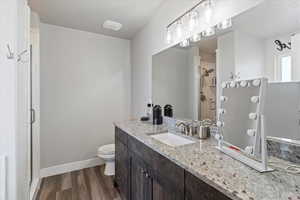 Bathroom featuring vanity, a shower stall, and dark wood-style flooring