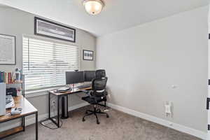 Office area with light colored carpet and lofted ceiling