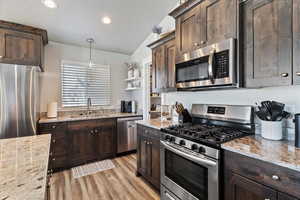 Kitchen featuring stainless steel appliances, dark brown cabinetry, open shelves, pendant lighting, and recessed lighting