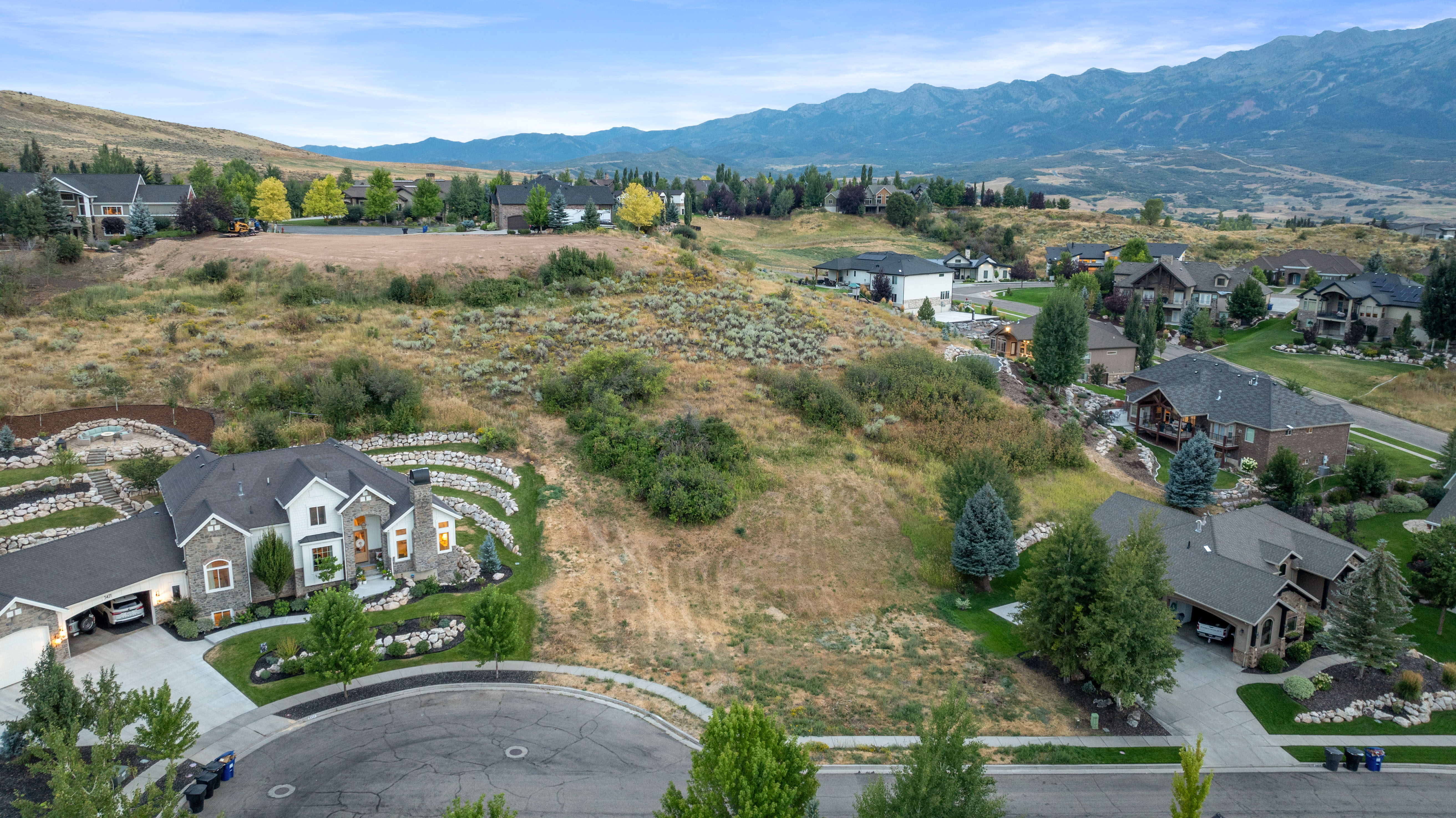 Aerial view of property's location with a mountainous background and nearby suburban area