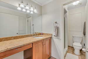 Bathroom featuring a stall shower, vanity, ornamental molding, and light tile patterned floors