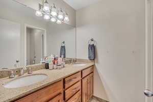 Bathroom featuring double vanity and toilet