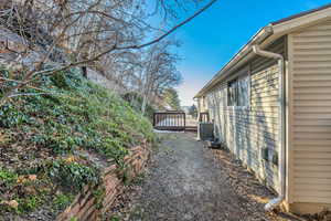 View of side of property with a deck and a central AC unit