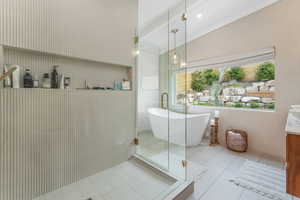 Full bath with tile patterned flooring, a freestanding tub, and a shower stall