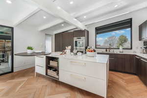 Kitchen featuring dark brown cabinets, light stone countertops, white cabinetry, modern cabinets, and recessed lighting