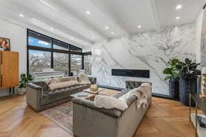 Living area with recessed lighting, stone wall, and beamed ceiling