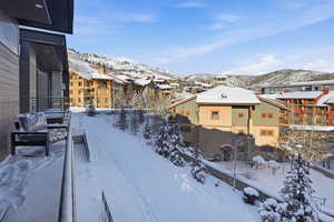 Yard layered in snow featuring a balcony and a mountain view