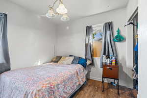 Bedroom with hardwood / wood-style floors and a chandelier