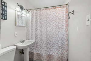 Full bath featuring toilet and shower / bath combo with shower curtain