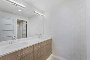 Bathroom with double vanity and tile walls
