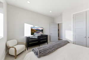 Carpeted bedroom featuring recessed lighting and a closet