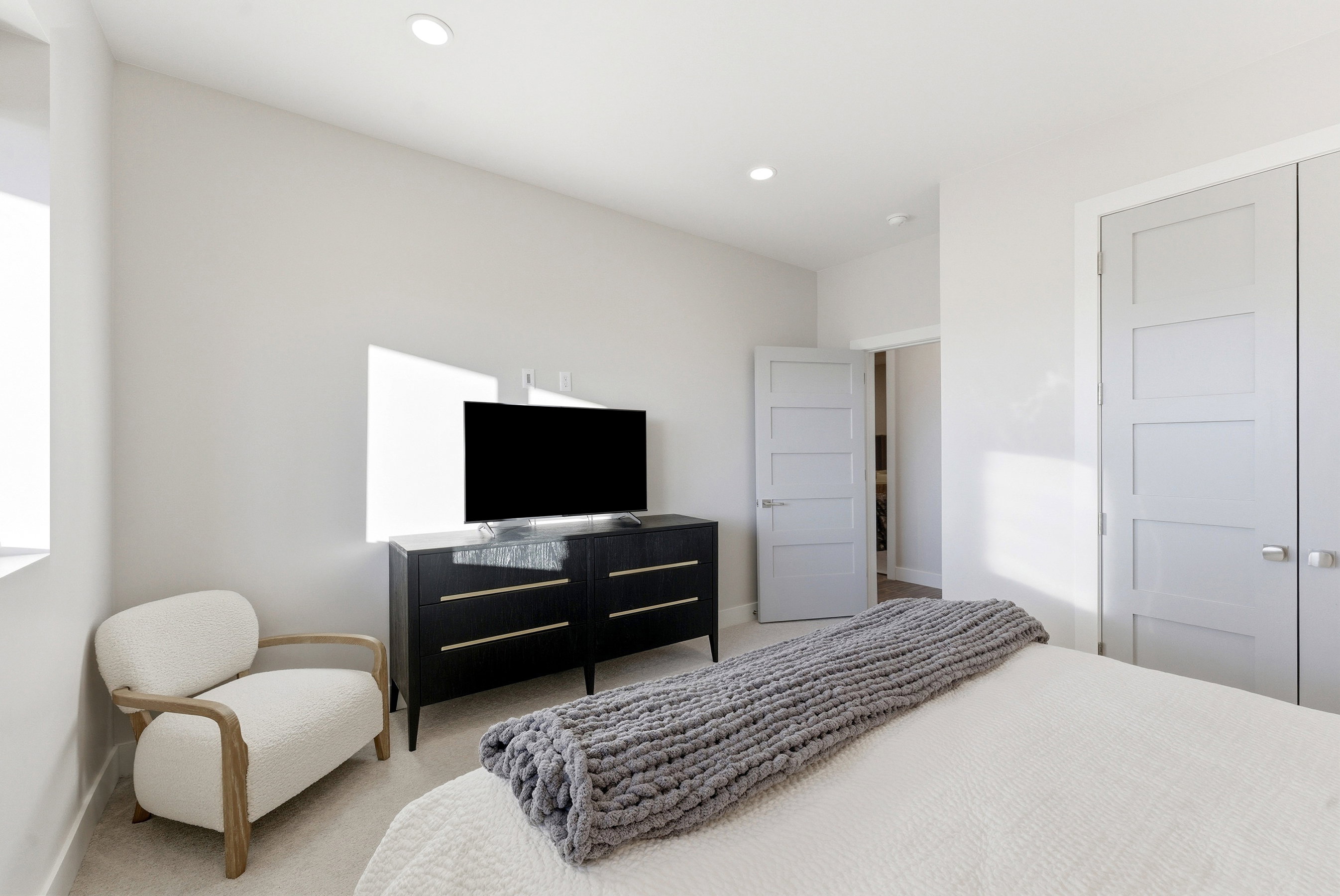 Neutral-toned interior with recessed lighting, light-colored walls, and gray four-panel interior doors