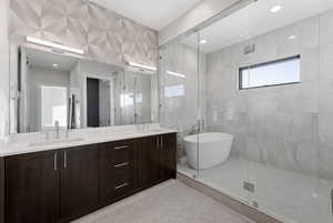 Full bath with a soaking tub, double vanity, light tile patterned floors, a shower stall, and recessed lighting