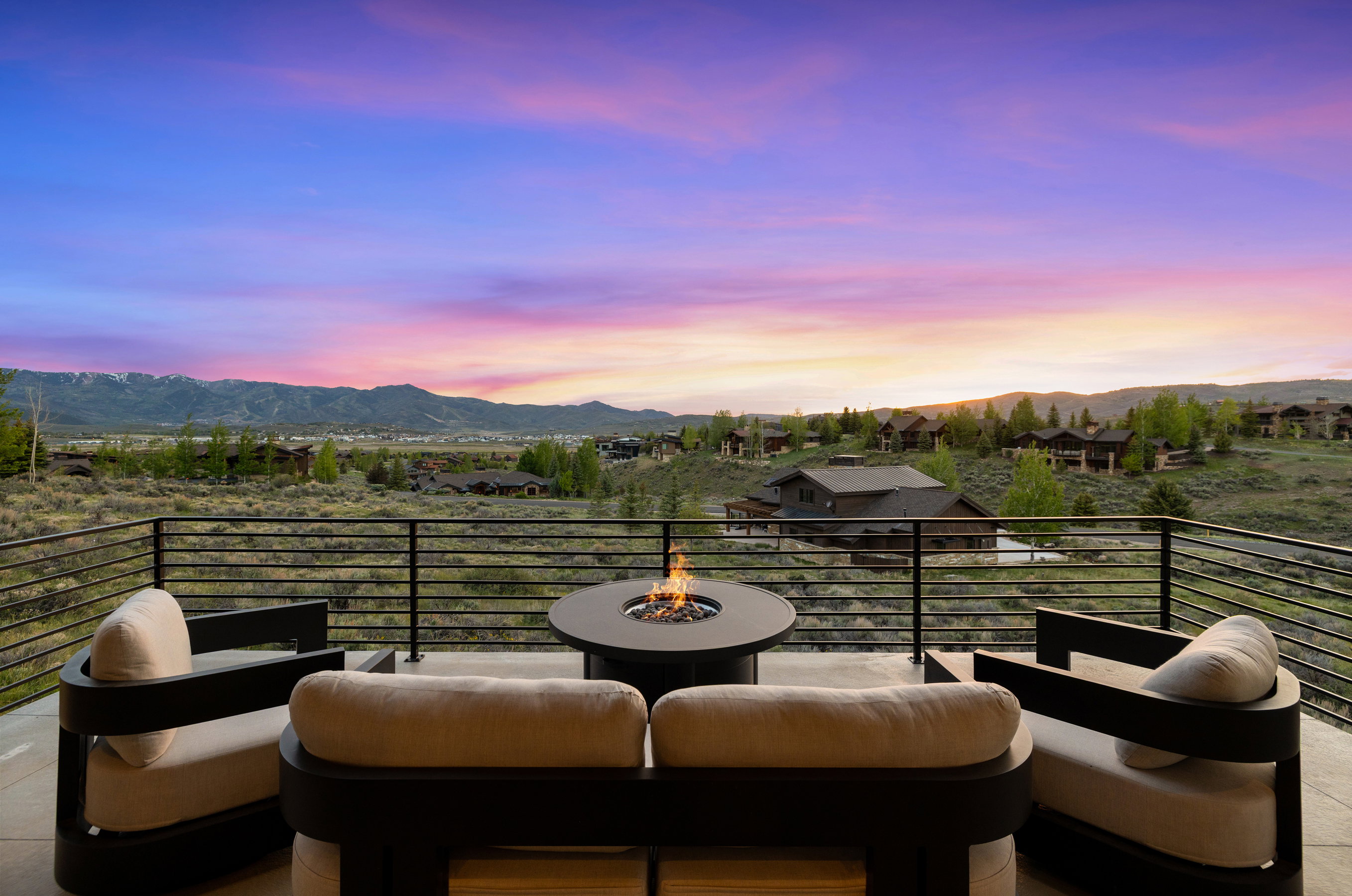 Spacious outdoor patio featuring a built-in fire pit and contemporary railing