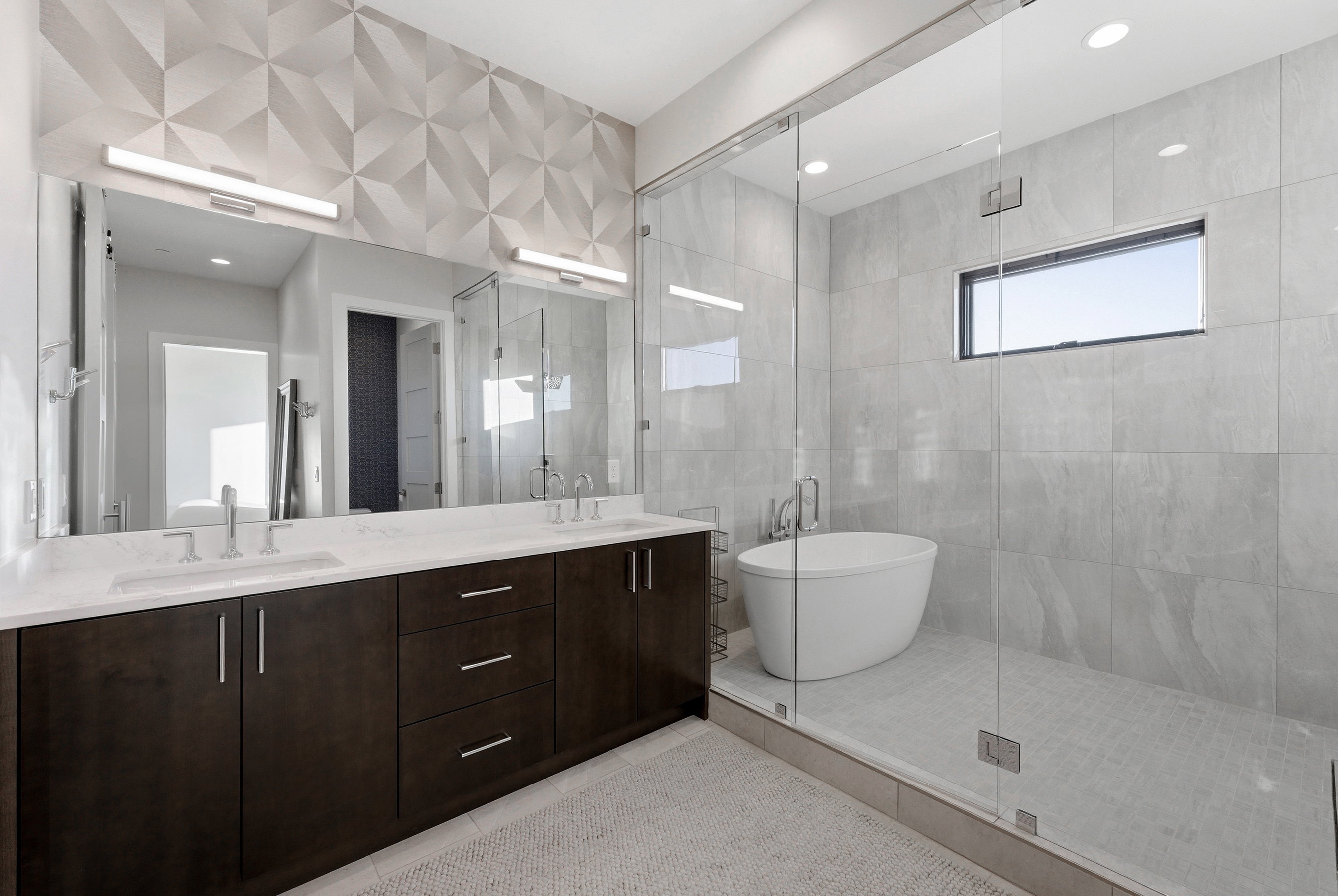 Spacious bathroom featuring a dual vanity with dark wood cabinetry and white countertops