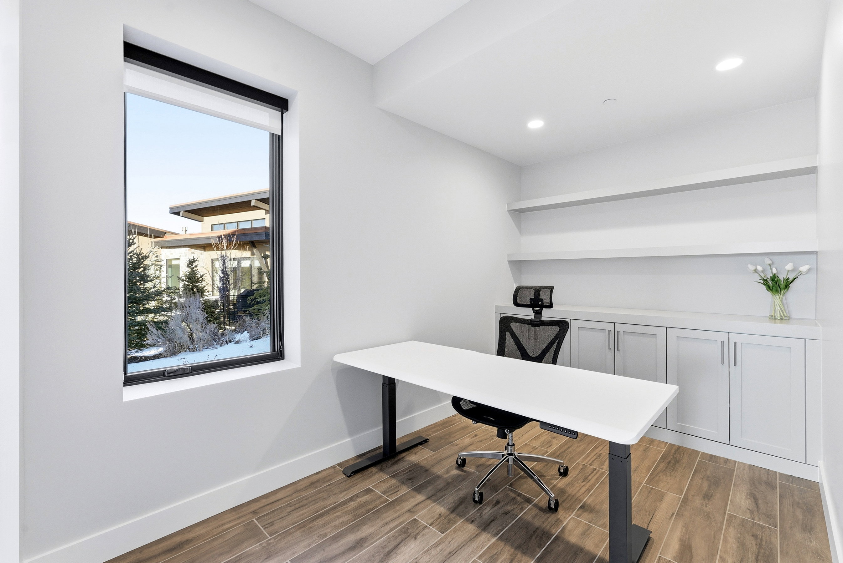Dedicated space featuring built-in cabinetry, floating shelving, recessed lighting, and wood-finish flooring