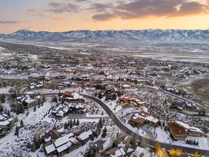 Snowy aerial view with a mountain view and a residential view