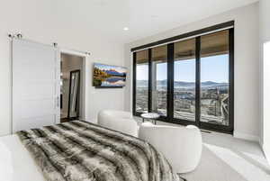 Bedroom with access to outside, carpet flooring, and a barn door