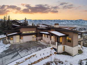 View of front of property with a metal roof, a chimney, stone siding, a mountain view, and a garage