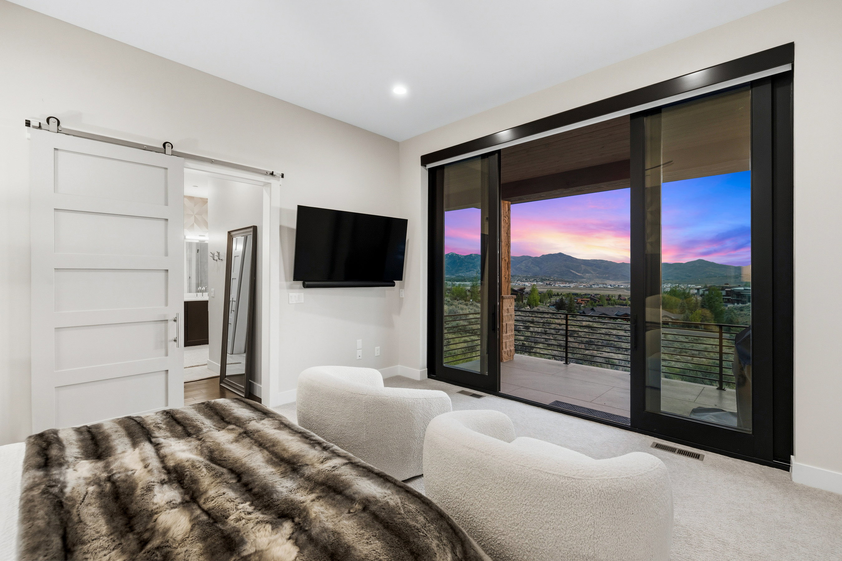 Expansive sliding glass doors opening to an outdoor balcony with mountain scenery