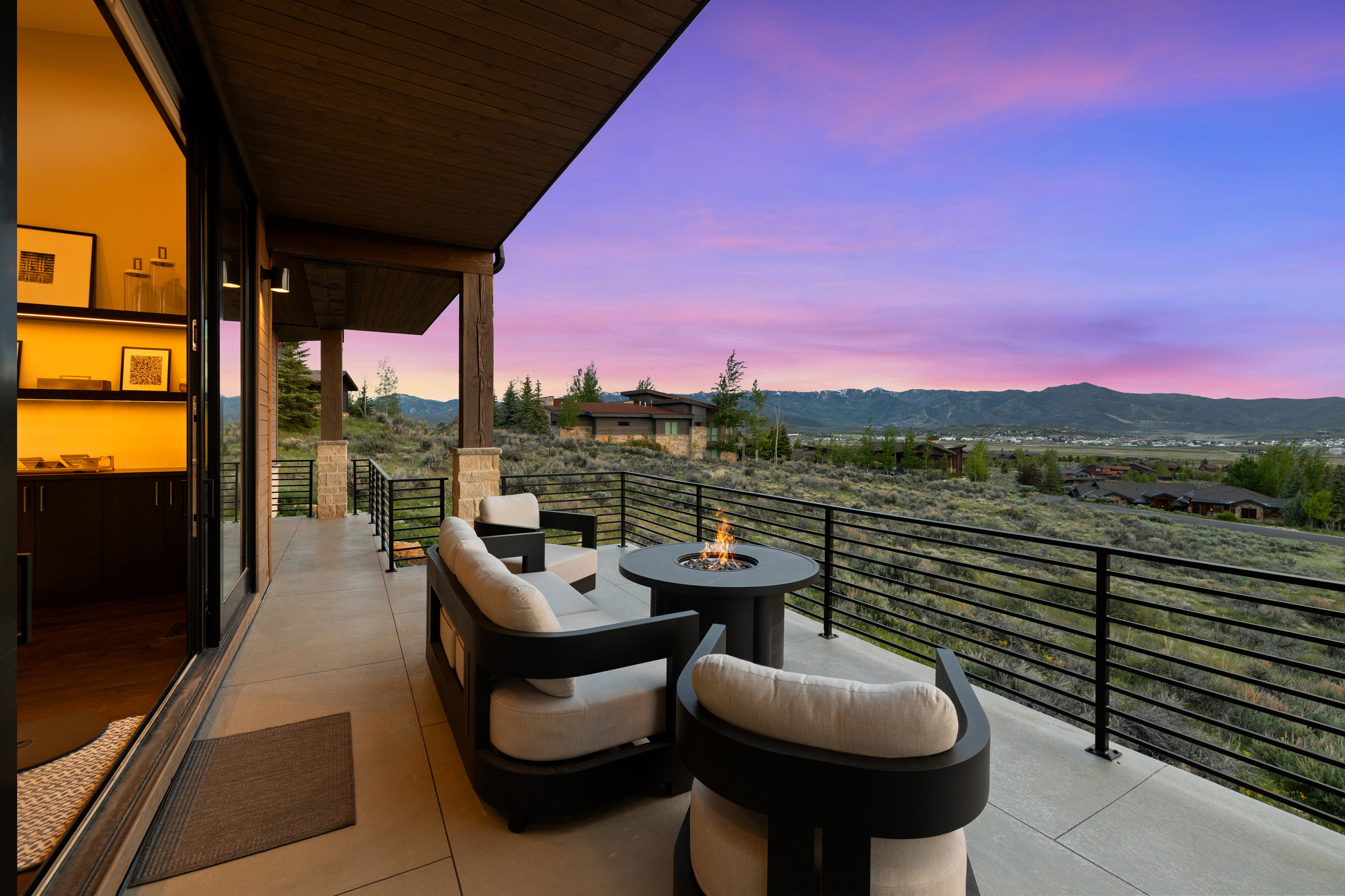 Expansive outdoor patio featuring a concrete surface, a built-in fire pit, and durable black metal railings