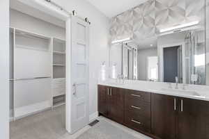 Full bath with double vanity and a walk in closet