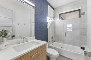 Full bathroom with bath / shower combo with glass door and vanity