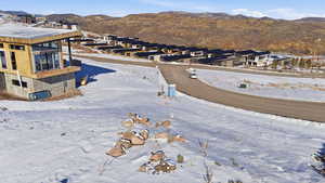 Snowy aerial view featuring a mountain view and a residential view