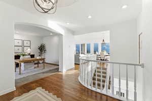 Hall featuring a chandelier, wood finished floors, recessed lighting, and arched walkways