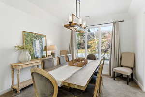 Dining room with carpet flooring and a chandelier