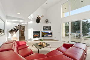 Living room with carpet, a fireplace, a towering ceiling, and recessed lighting