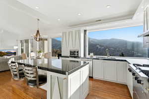 Kitchen featuring decorative light fixtures, a kitchen bar, a mountain view, a kitchen island, and light wood-style flooring