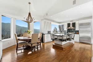 Dining space with plenty of natural light, recessed lighting, light wood-type flooring, and a chandelier