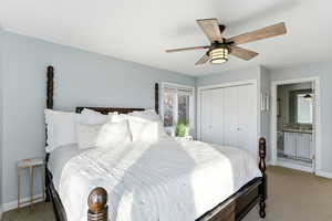 Carpeted bedroom featuring a closet, a ceiling fan, and connected bathroom