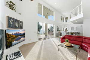 Carpeted living room featuring recessed lighting and a towering ceiling