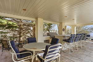View of patio with exterior kitchen and outdoor dining space