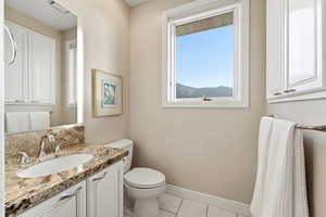 Half bath featuring vanity and light marble finish floors