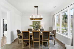 Carpeted dining space featuring arched walkways and baseboards