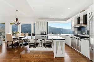 Kitchen with white cabinetry, a breakfast bar, decorative light fixtures, backsplash, and a mountain view