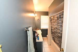 Bathroom featuring vanity, light tile patterned floors, and shower / bath combo