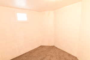Carpeted empty room with a textured ceiling