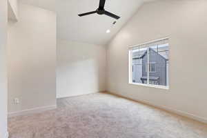 Spare room with lofted ceiling, light colored carpet, ceiling fan, and recessed lighting