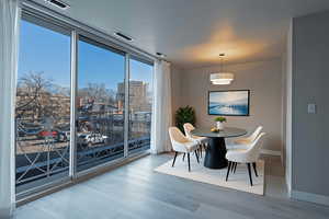 Dining area with expansive windows and light wood-style floors